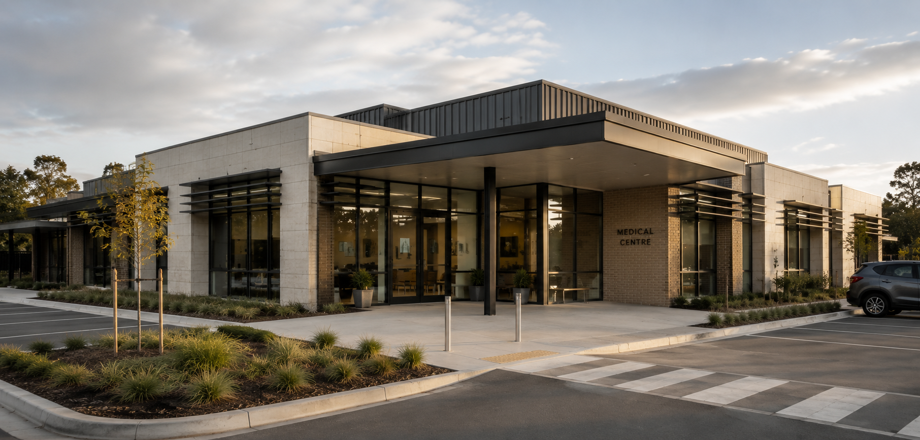 Commercial façade detail showing external shading, black-framed glazing and textured concrete panels